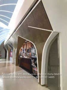 Decorative metal archway and wall cladding by XYC METALWORKS at a Doha Metro station commercial area.