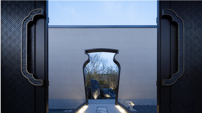 Close-up of a custom-designed Chinese style metal gate with intricate laser-cut patterns and a unique vase-shaped doorway frame.