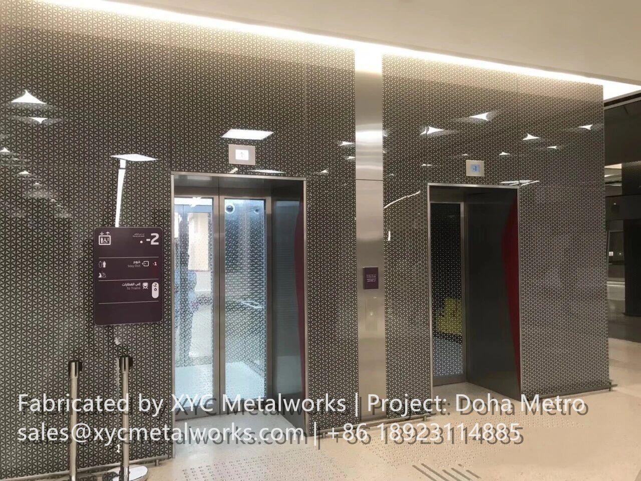 Decorative perforated metal elevator facade by XYC Metalworks at a Doha Metro station, featuring intricate patterns and integrated signage.