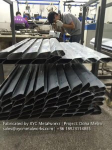 XYC Metalworks craftsmen finishing high-grade stainless steel architectural profiles in the factory for the Qatar Rail network.